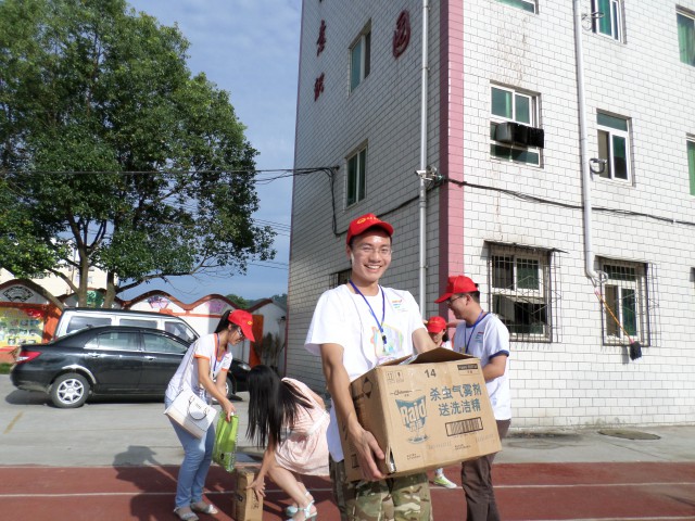 志愿者抱着募捐来的爱心礼物到达小学